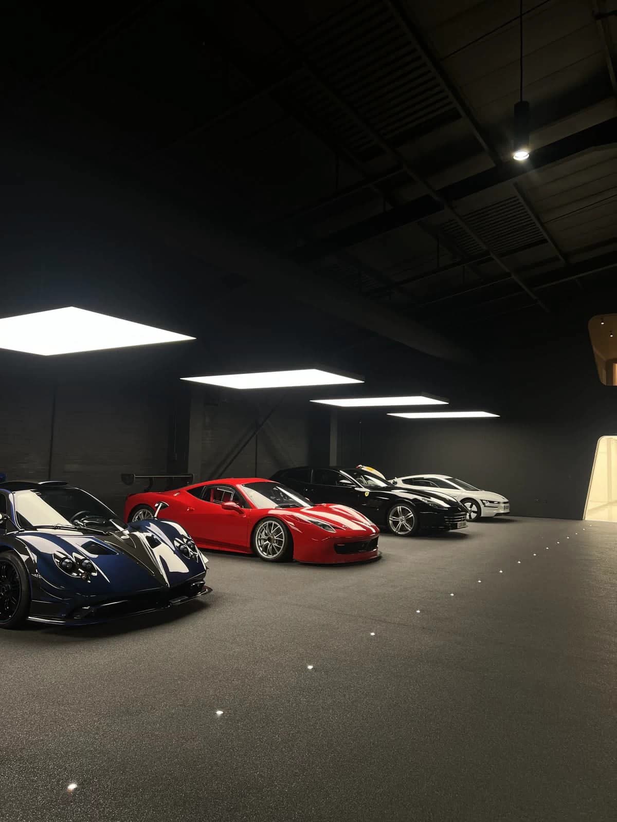 Collector cars arranged in a dark gallery