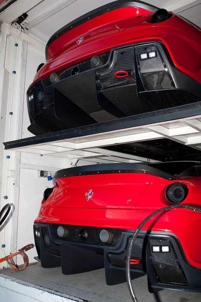 Historic racing cars stored together on a lift
