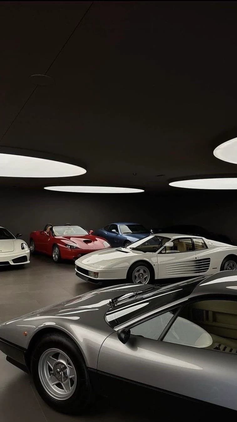 Collector cars displayed together in a dark gallery