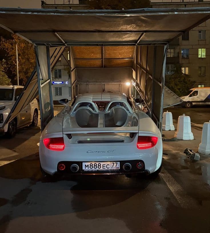 A collector car being unloaded at night