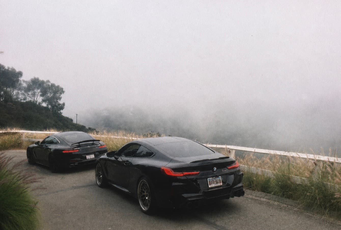 Collector cars travelling together on a foggy road