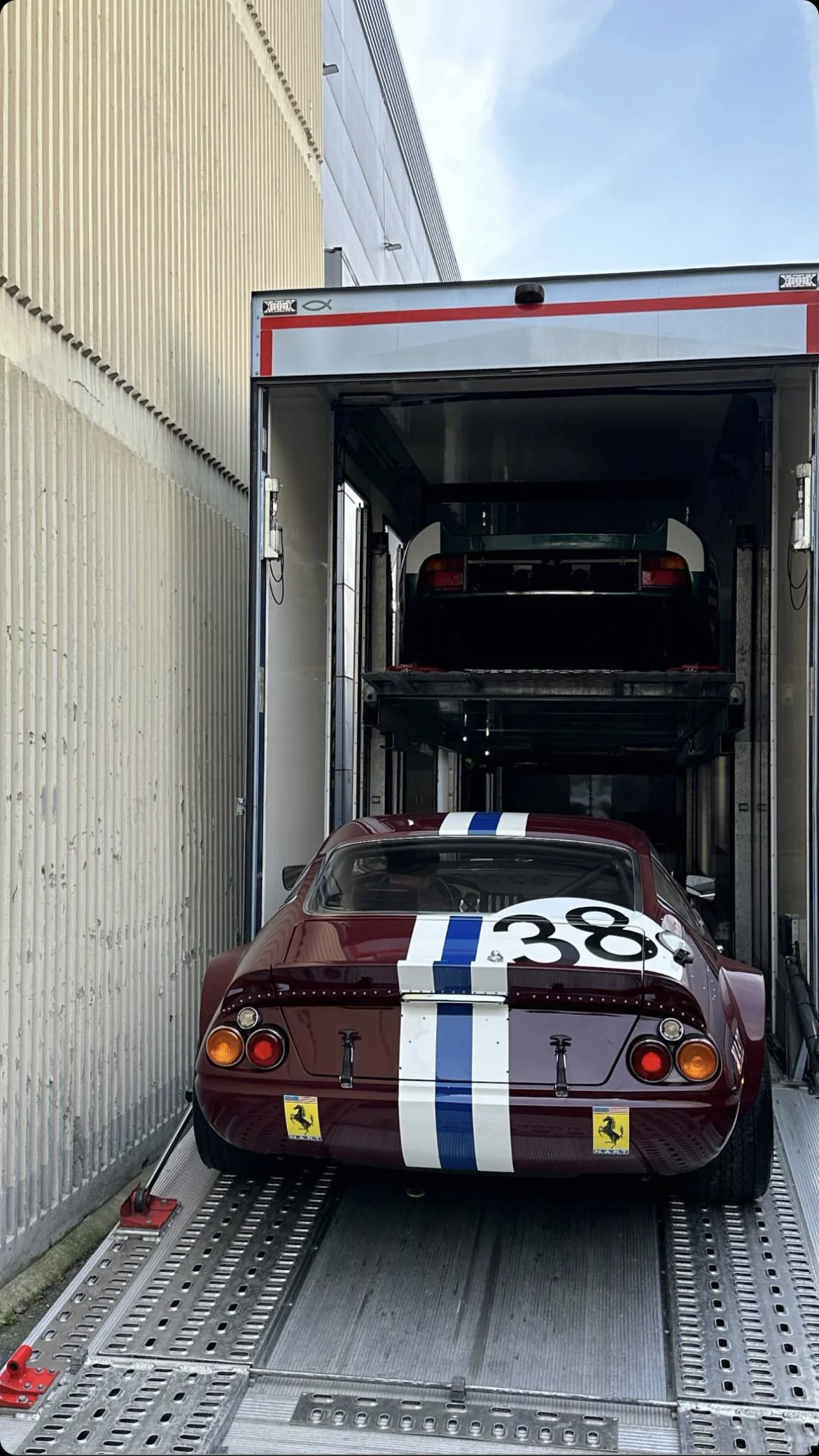 A historic race car being moved by enclosed transport