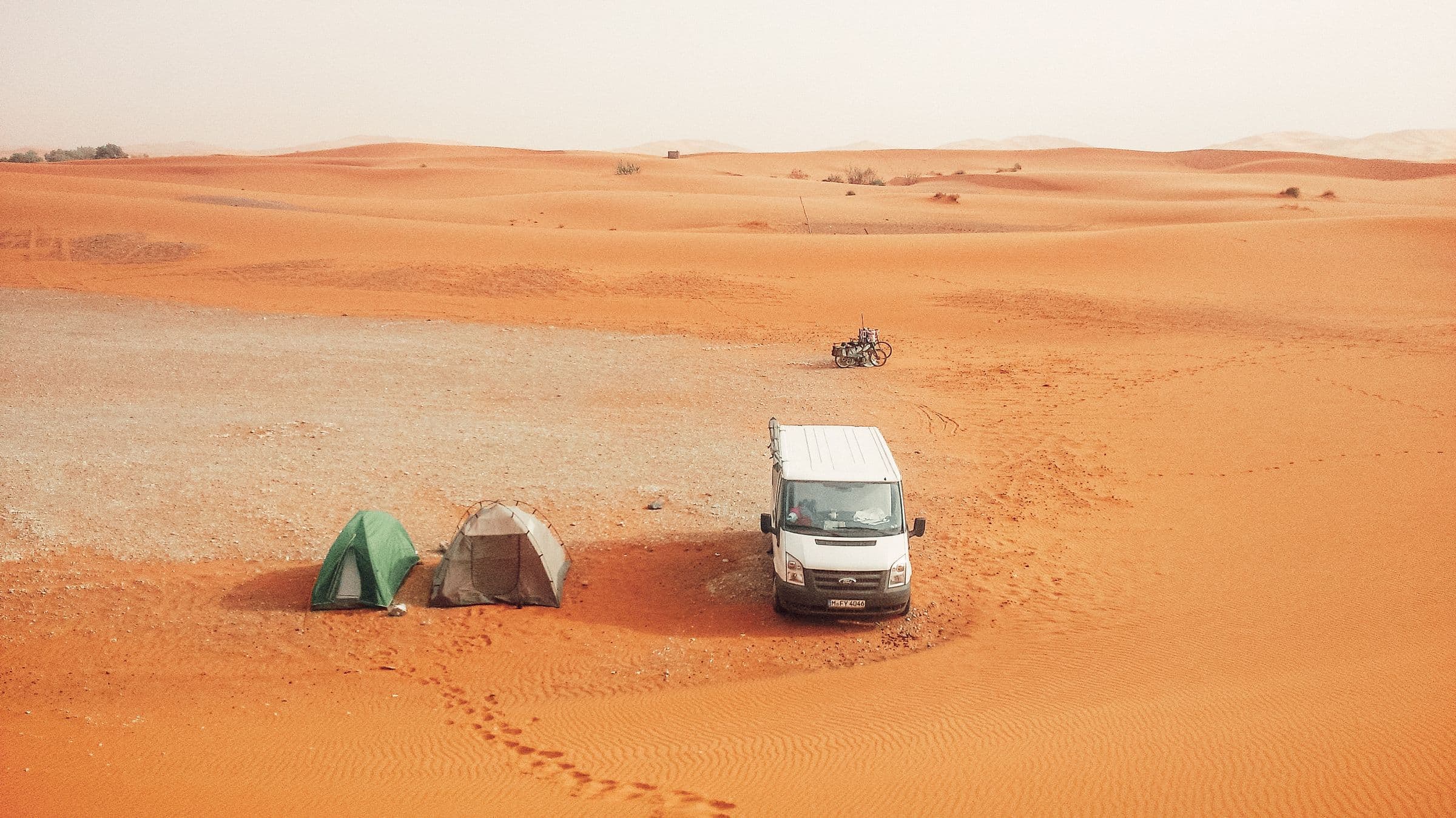 A desert road beside a prepared 4x4 camp